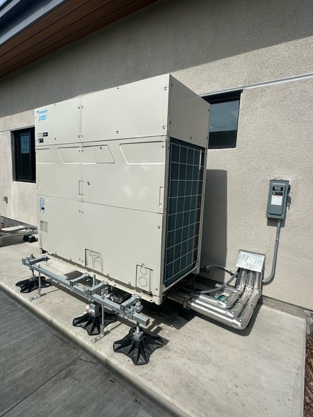 Daikin VRV outdoor heat pump on a pipe stand with insulated refrigerant piping