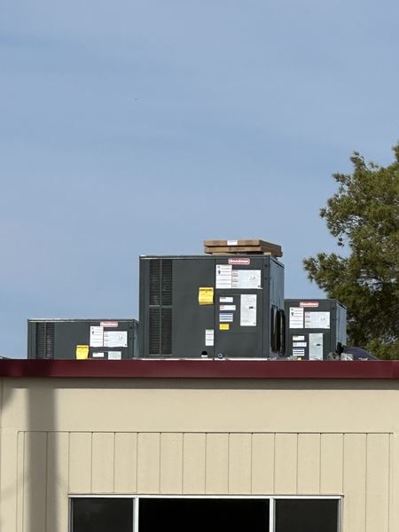 Packaged HVAC units set on the roof of a modular classroom building